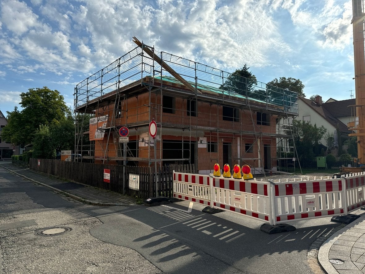 Fertigbaustelle an Ecke; Gebäude mit Gerüsten und Absperrungen; Himmel bewölkt; Schild "Durchfahrt verboten".